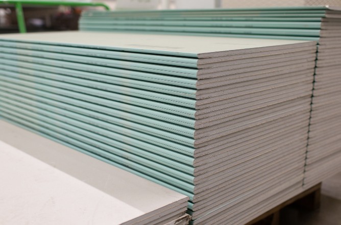 Placas de pladur antihumedad (verde) apiladas en almacén - materiales de calidad